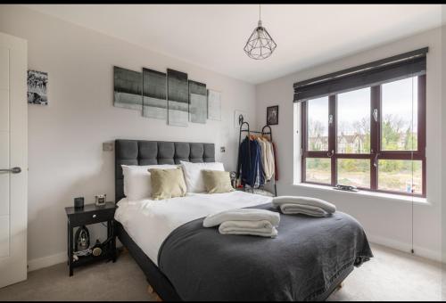a bedroom with a large bed and a window at Stylish Harbourside Apartment in Bristol