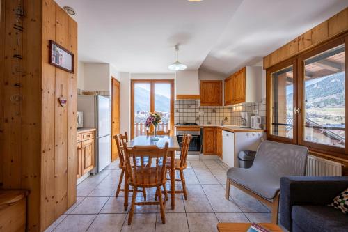 une cuisine et une salle à manger avec une table et des chaises dans l'établissement La Favière, à Val Cenis