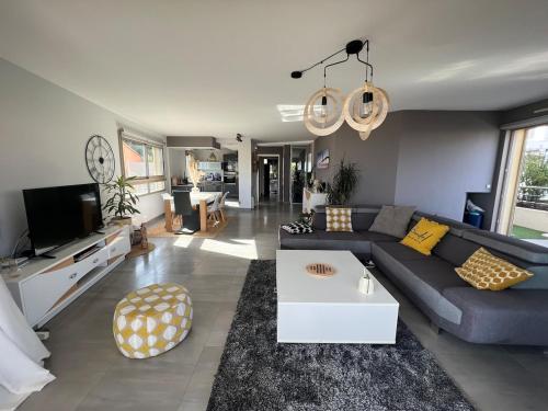 un salon avec un canapé bleu et une télévision dans l'établissement Havre de Paix au soleil, à Bandol