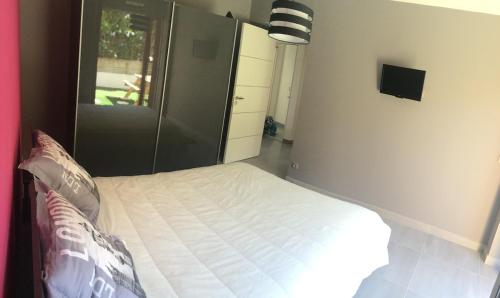 une chambre avec un lit blanc dans une pièce dans l'établissement Havre de Paix au soleil, à Bandol