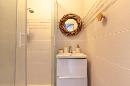 une salle de bain avec un lavabo et un miroir dans l'établissement Sanary Sur Mer,Soleil Et Douceur Il, à Sanary-sur-Mer