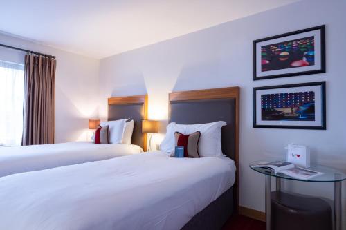 a hotel room with two beds and a window at Bermondsey Square Hotel - A Bespoke Hotel in London