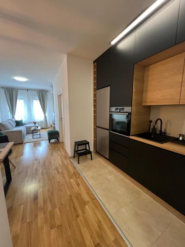 a kitchen with black cabinets and a living room at Loyal 1 in Arandjelovac