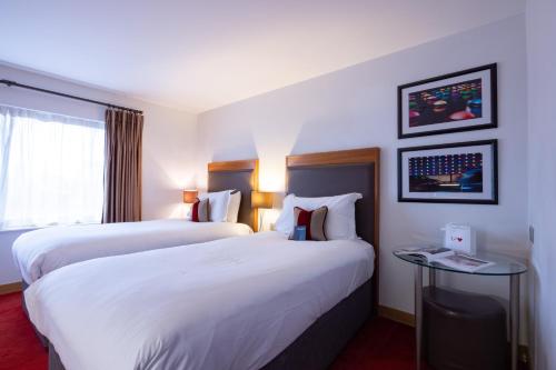 a hotel room with two beds and a window at Bermondsey Square Hotel - A Bespoke Hotel in London