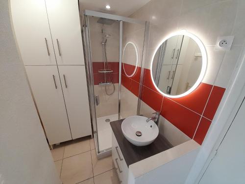 une salle de bain avec un lavabo et un miroir dans l'établissement Studio Village Naturiste Pina Colada, au Cap d'Agde