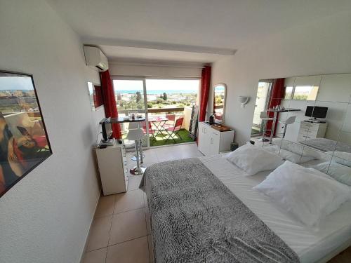 une chambre avec un grand lit et un balcon dans l'établissement Studio Village Naturiste Pina Colada, au Cap d'Agde