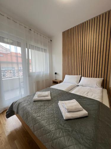 ein Schlafzimmer mit einem Bett, auf dem zwei Handtücher liegen in der Unterkunft Loyal 1 in Aranđelovac