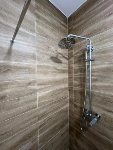 a shower in a bathroom with a wooden wall at Loyal 1 in Arandjelovac