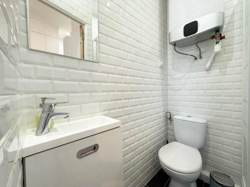 une salle de bain blanche avec des toilettes et un lavabo dans l'établissement Charming studio for 2 guest - 2min walk from metro, à Paris