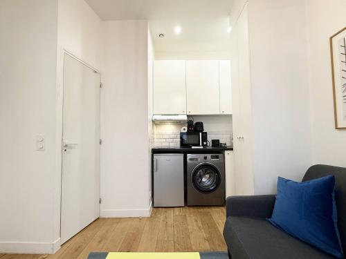 - une cuisine avec un lave-linge dans le salon dans l'établissement Charming studio for 2 guest - 2min walk from metro, à Paris