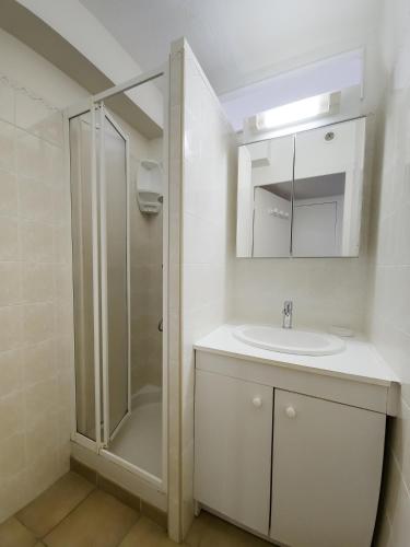une salle de bain blanche avec un lavabo et une douche dans l'établissement Les Terrasses de Cavald'Or - T2 with pool, au Lavandou