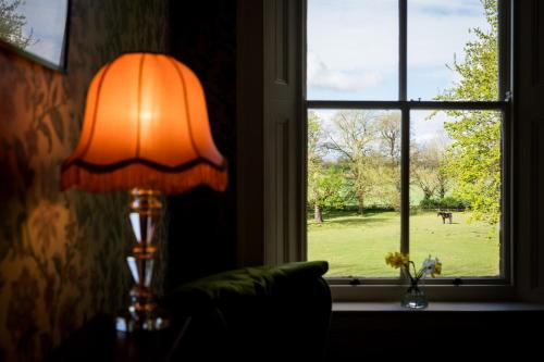 a lamp sitting on a table next to a window at Charming 18th Century property in Topcliffe Station