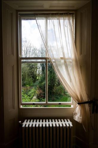 a window with a curtain and a radiator in a room at Charming 18th Century property in Topcliffe Station