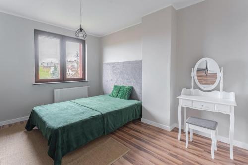 a bedroom with a bed and a mirror and a sink at Apartament Pomarańczowy Gdańsk 80 metrów z widokiem na ogród in Gdańsk