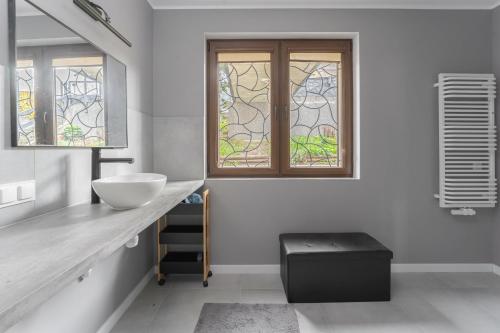a bathroom with a sink and a window at Apartament Pomarańczowy Gdańsk 80 metrów z widokiem na ogród in Gdańsk