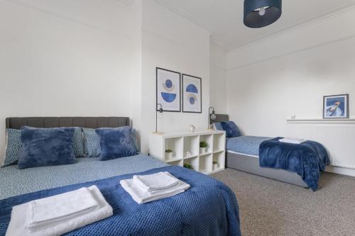 a bedroom with two beds with towels on them at The Turnpike Residence - Free Parking in London