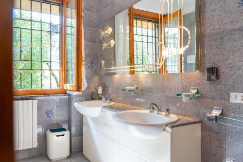 une salle de bain avec deux lavabos et un miroir dans l'établissement Villa Punta Sasso, à Manerba del Garda