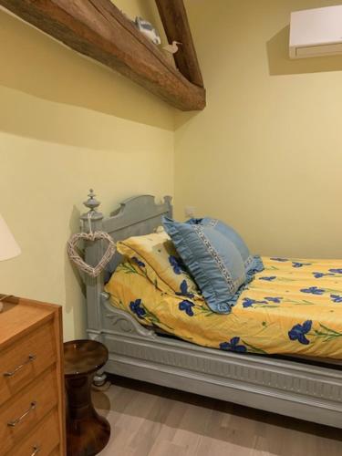 une chambre avec un lit avec des oreillers bleus dessus dans l'établissement Au vieux pressoir, à Montans