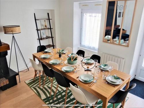 une salle à manger avec une table et des chaises en bois dans l'établissement La maison Haute, à Guer