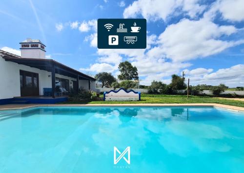 a swimming pool in front of a house with a sign at MyStay - Casa do Guizo in Mértola