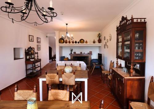 a living room with a bed and a dining room at MyStay - Casa do Guizo in Mértola