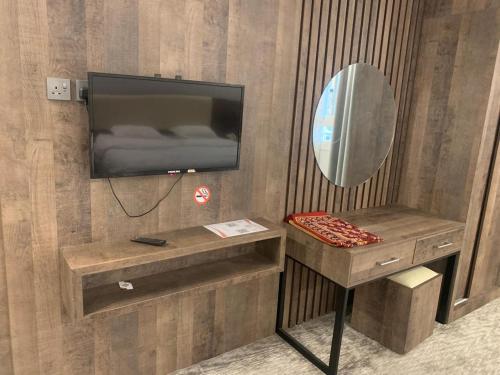 a room with a television and a table with a mirror at اعالي للشقق المخدومه in Abha