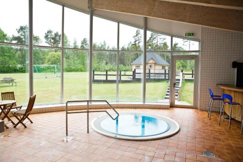 Cette grande chambre dispose d'une piscine au milieu d'une pièce avec fenêtres. dans l'établissement Ljungsbro Vandrarhem, à Ljungsbro