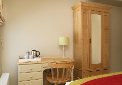 a wooden desk with a chair and a cabinet at The Greyhound Inn in Wantage