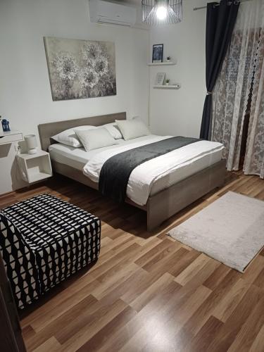 a bedroom with a bed and a ottoman in it at Josipa & Jelena Apartment in Senj