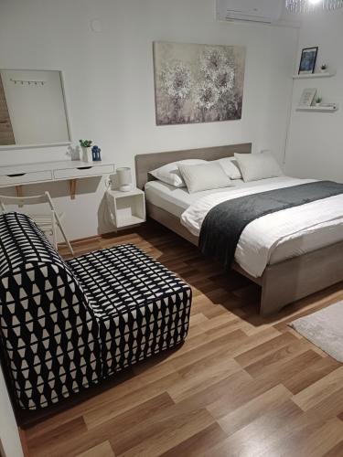 a bedroom with a bed and a chair and a desk at Josipa & Jelena Apartment in Senj