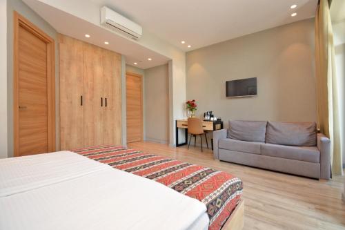 a bedroom with a bed and a couch and a table at Andor Hotel in Yerevan