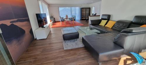 a living room with a couch and a tv at BellaRosa in Emmetten