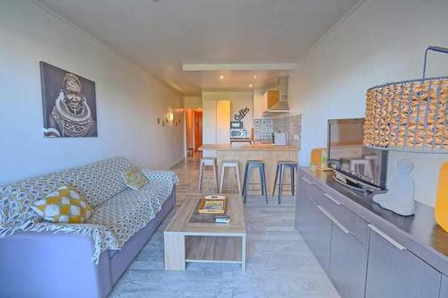 un salon avec un canapé et une table dans l'établissement Juan les pins Tanit Le Gébal Studio Climatisé vue sur mer Piscine, à Antibes