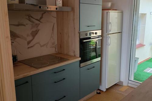 une cuisine avec une cuisinière et un réfrigérateur dans l'établissement Apartment with terraces in Rayol-Canadel-sur-Mer, à Rayol-Canadel-sur-Mer