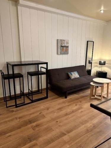 - un salon avec un canapé noir et des tables dans l'établissement BOSIO RAOUL - Central and steps away from the sea, à Nice