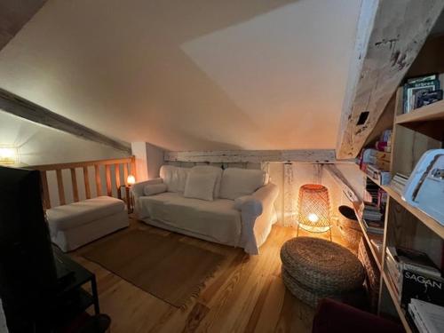 - un salon mansardé avec un canapé blanc dans l'établissement La Landaise - Les Maisons Huraia, à Vielle-Saint-Girons