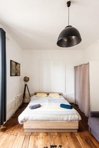- une chambre avec un lit et une lampe noire dans l'établissement Karijini Apartment 1 bedroom - City Center - Poitiers, à Poitiers