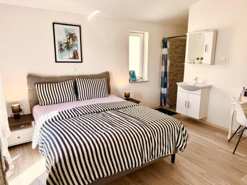 - une chambre dotée d'un lit avec une couverture rayée noire et blanche dans l'établissement Villa Sarah Medulin, à Medulin