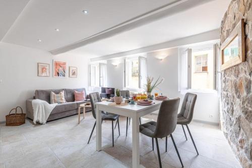 un salon avec une table, des chaises et un canapé dans l'établissement MALONAT - Cosy Apart in Old Town w AC, à Nice
