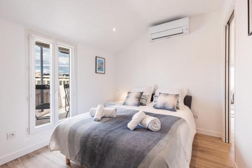 - une chambre blanche avec un grand lit et des serviettes dans l'établissement SPITALIERI 2 - Superb Terrace Panoramic View AC, à Nice