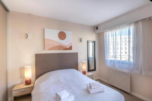 une chambre avec un grand lit blanc avec deux lampes dans l'établissement JOFFRE 2-4 - Bright Central 1 bedroom Near Massena, à Nice