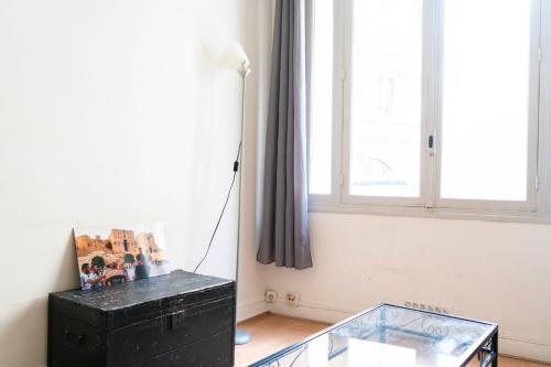 une chambre avec une table en verre et une lampe dans l'établissement Charming studio with view near Montmartre, à Paris
