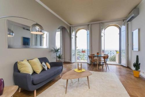 un salon avec un canapé bleu et une table dans l'établissement ETATS UNIS 894 - Stunning on Sea Front w AC, à Nice