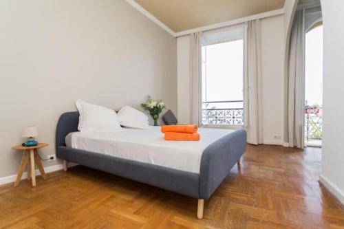 - une chambre dotée d'un lit avec des oreillers orange dans l'établissement ETATS UNIS 894 - Stunning on Sea Front w AC, à Nice