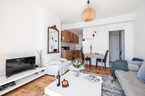 un salon avec un canapé et une télévision dans l'établissement ETAT UNIS 93 INDIGO - Amazing Sea View Aprt with AC, à Nice