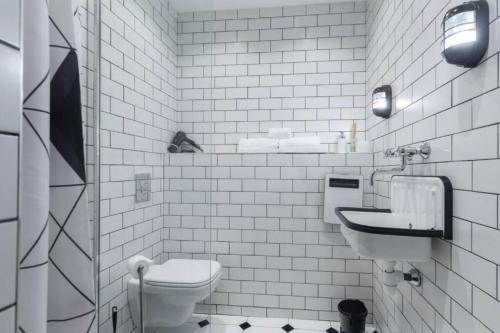 une salle de bain blanche avec des toilettes et un lavabo dans l'établissement DROITE - Bright studio in the Old Town, à Nice