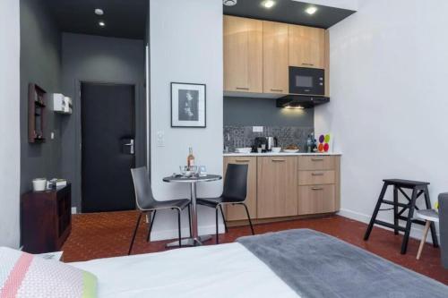 Cette chambre comprend un lit, une table et une cuisine. dans l'établissement DROITE - Bright studio in the Old Town, à Nice