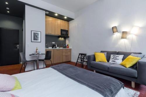 Cet appartement comprend une chambre avec un lit et un canapé ainsi qu'une cuisine. dans l'établissement DROITE - Bright studio in the Old Town, à Nice