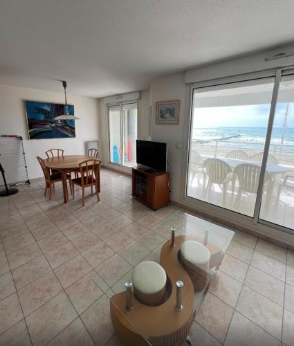 - un salon avec une table et une vue sur l'océan dans l'établissement Bright seafront apartment, à Palavas-les-Flots