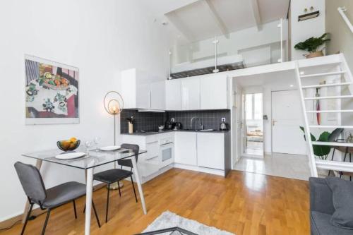 une cuisine avec des armoires blanches et une table et des chaises dans l'établissement DELOYE - Spacious Quiet studio wAc near Old Town, à Nice